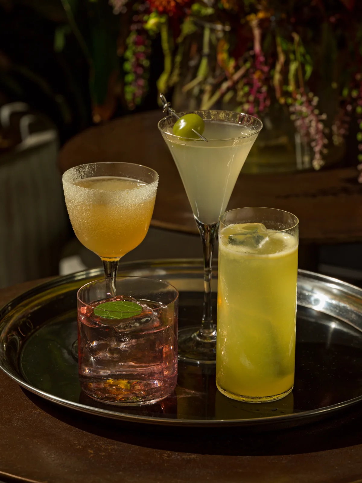 Four cocktails on a silver tray at Darling