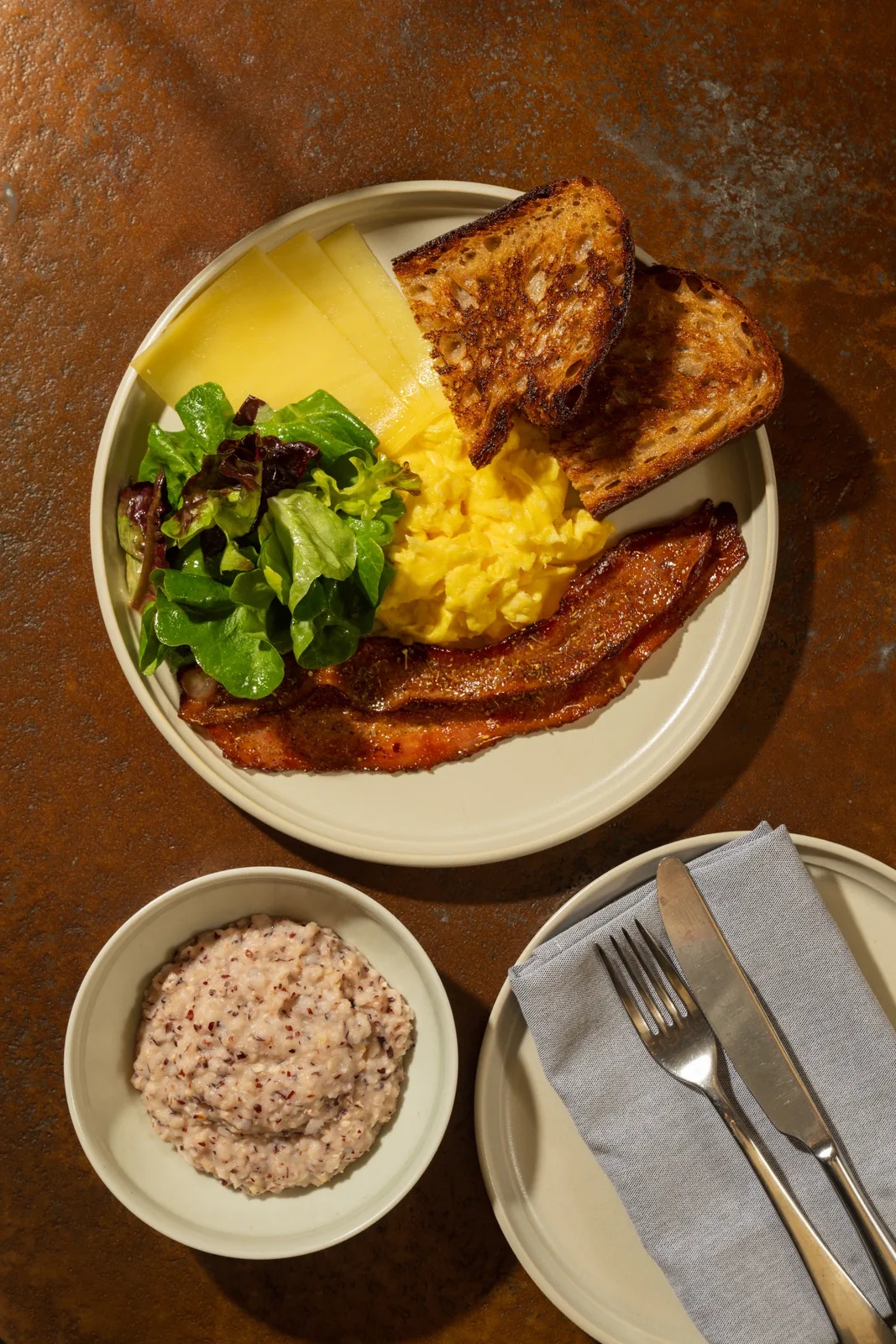 The breakfast plate, scrambled eggs, bacon, toast, and grits