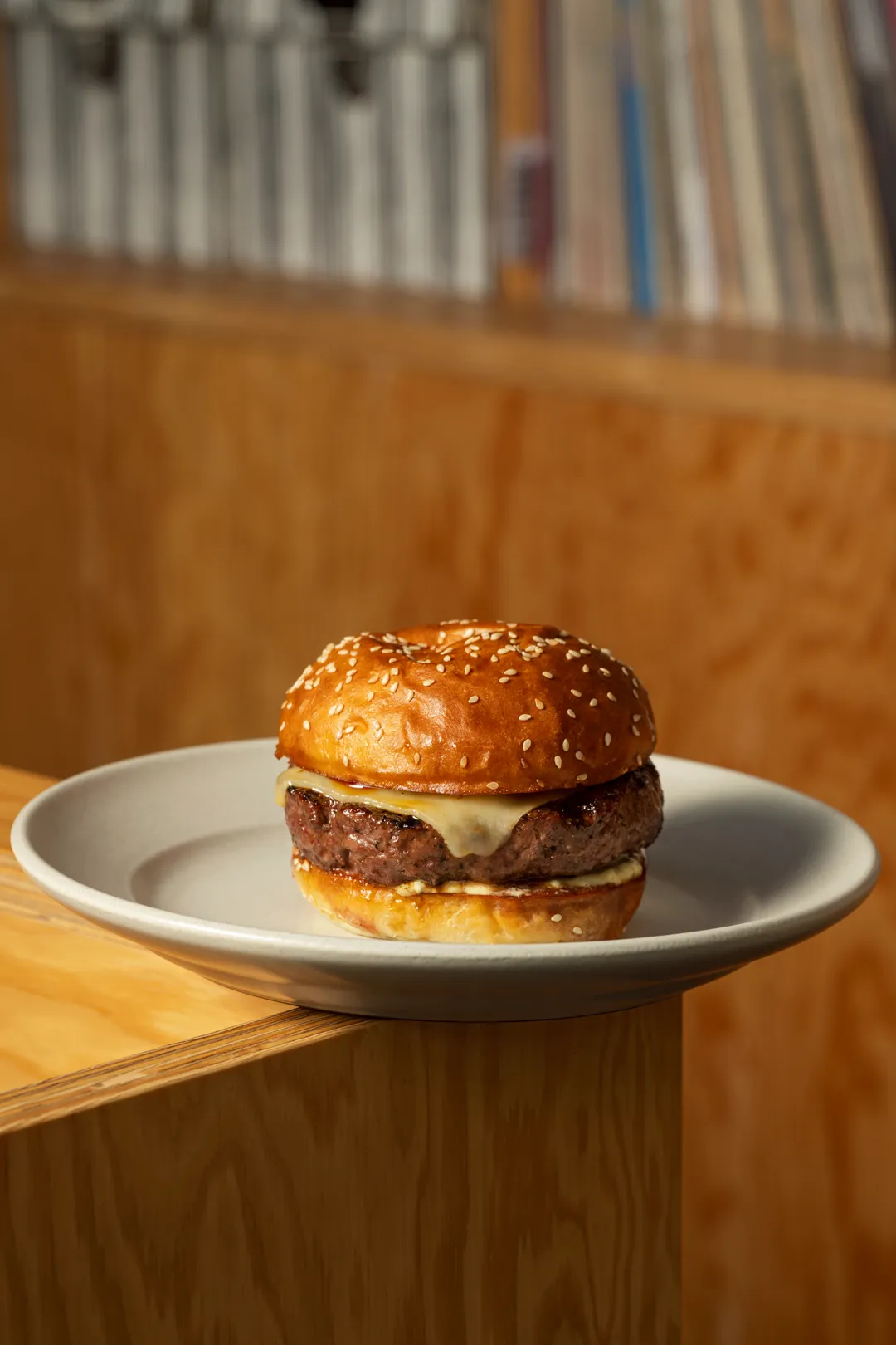 The dry-aged steak burger on a sesame bun by the record shelves