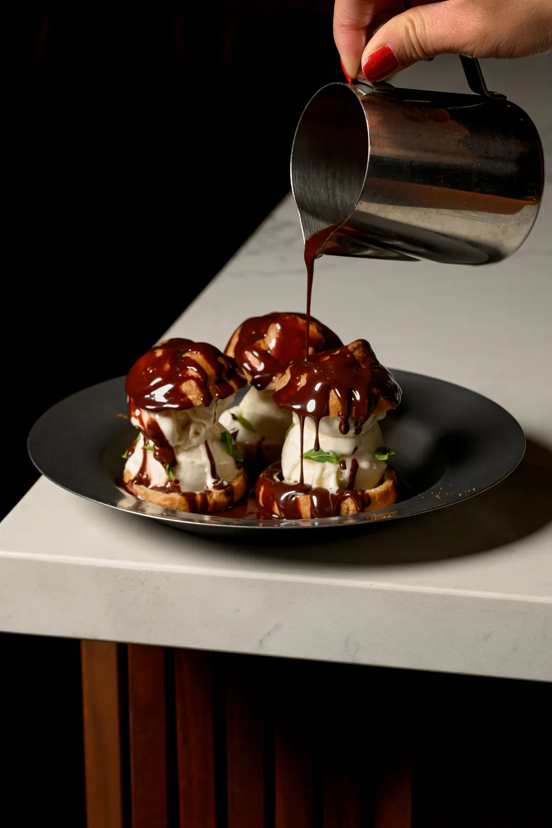 Profiteroles with vanilla ice cream and warm chocolate sauce