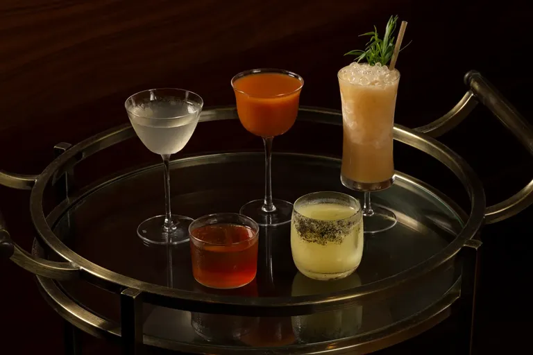 Craft cocktails on a brass bar cart at Darling